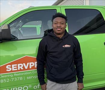 Man with hooded sweatshirt in front of green truck