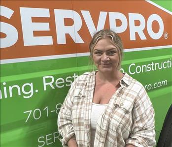blond lady standing in front of Servpro van